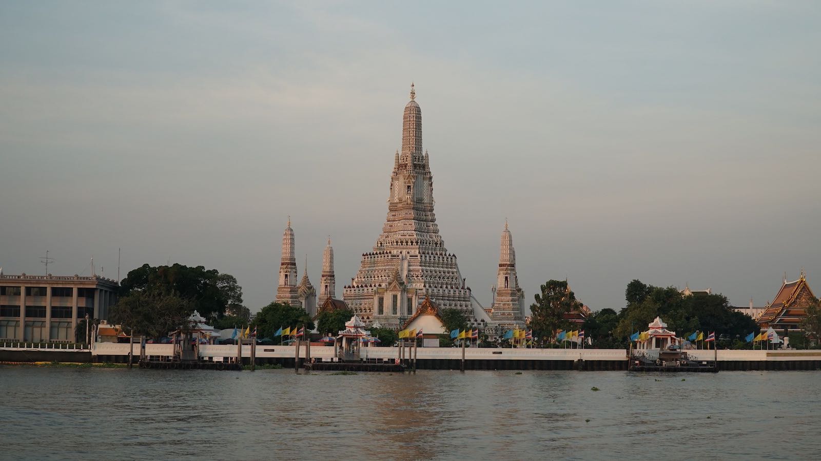 Wat Arun (Temple of Dawn) one of the most recognizable templates in Bangkok. Taking this photo was quite the struggle. The template is situated on the banks of the river. Across the water, the entire opposite bank is lined with residential homes or shops and businesses that weren't open yet. I wanted a shot from across the river and I ran around to find a section of the riverbank that was open to the public but never found it. I wanted to photograph the temple before the sun completely rose and was running out of time looking for a public view. I ended up sneaking into the patio of a boutique coffee shop to take this photo, until the owner came by to open the shop and kicked me out.